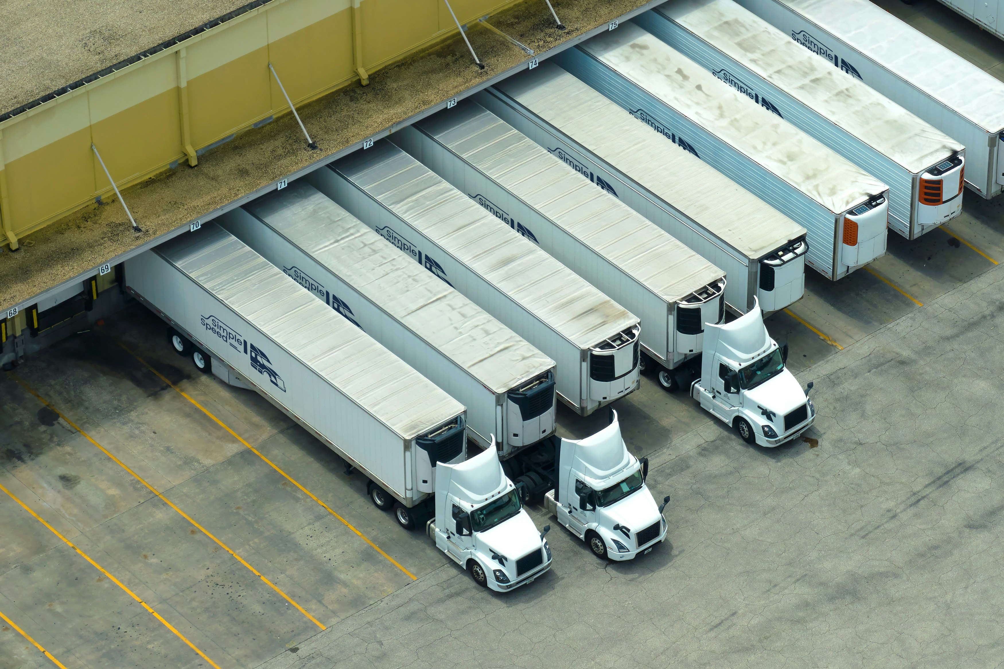 Simple Speed logistics facility with fleet of refrigerated trucks at loading docks